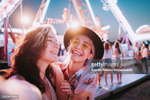 couple taking selfies at a fair - festival stockfoto's en -beelden