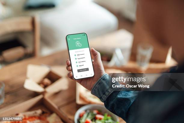 ordering food delivery on smart phone - over the shoulder view stock pictures, royalty-free photos & images
