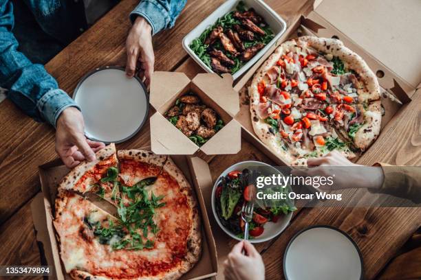 couple sharing takeaway meal at home - pizza from above stock pictures, royalty-free photos & images
