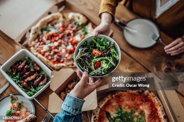 couple sharing takeaway meal at home - salad to go stock pictures, royalty-free photos & images