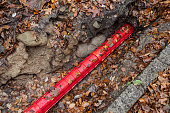 Communication Cables covered by red plastic flexible tube, Network Buildout high-speed Internet Network cables in red Cable Protector Wire Cover are buried underground on Construction site.