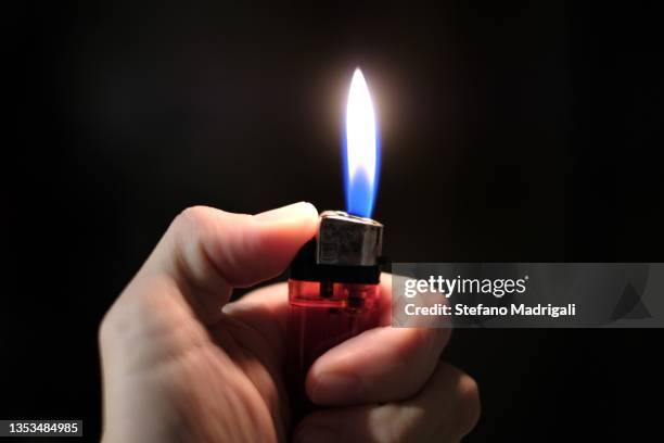 hand of a man using the lighter in the dark - cigarette lighter stockfoto's en -beelden