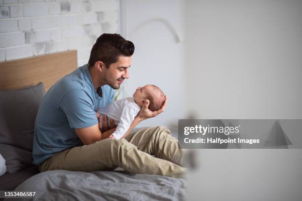 young father enjoying time together with newborn baby girl at home. - baby father hug side stock-fotos und bilder