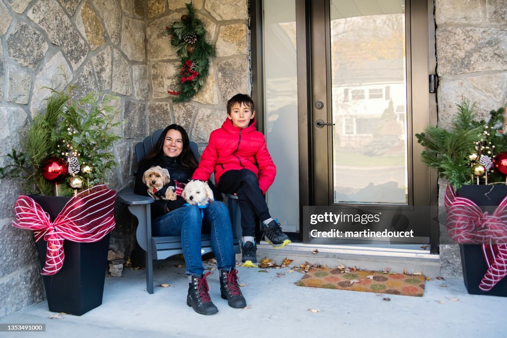 Holiday season portrait of mother, son and dogs outdoors.