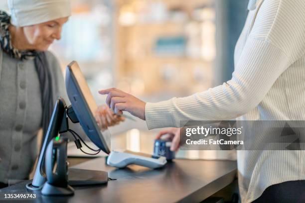 cannabis retailer ringing in a cancer patients purchase - cannabis business stock pictures, royalty-free photos & images