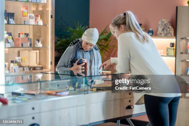 senior woman with cancer shopping for cannabis - cannabis business stock pictures, royalty-free photos & images