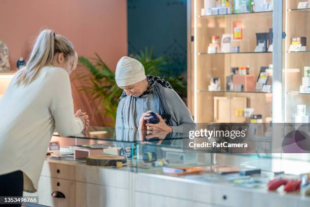 une femme âgée atteinte de cancer magasine pour le cannabis - coffee shop photos et images de collection