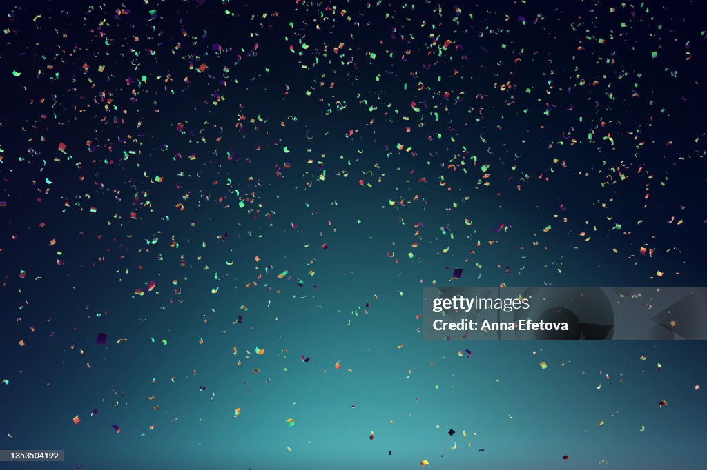 Many festive multi colored confetti falling against blue background. Concept of carnival or birthday celebration. Perfect backdrop for your design