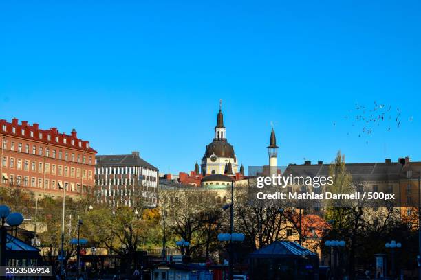 view of buildings in city against clear blue sky - darmell bildbanksfoton och bilder