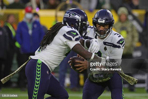 Russell Wilson of the Seattle Seahawks fakes a handoff to Alex Collins during a game against the Green Bay Packers at Lambeau Field on November 14,...