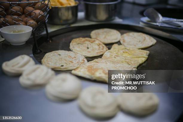 fried roti in pan. - roti canai stock pictures, royalty-free photos & images