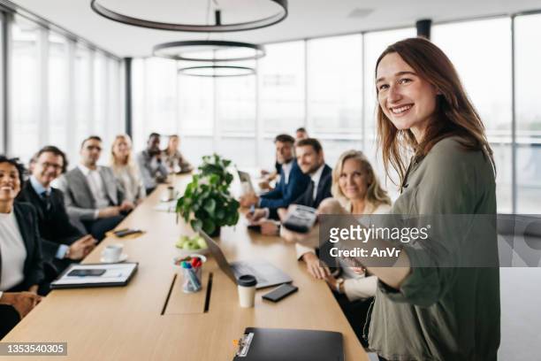 smiling business woman leading a meeting - teambuilding stockfoto's en -beelden