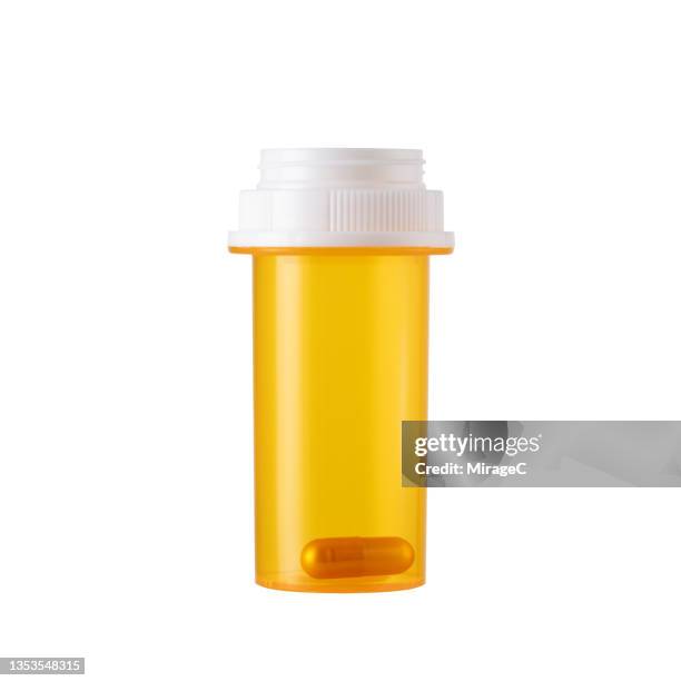 prescription medicine pill bottle with one last capsule on white - prescription drug bottle stock pictures, royalty-free photos & images