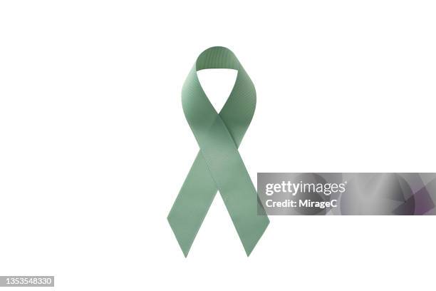 jade green ribbon isolated on white background - cancer ribbon stock-fotos und bilder