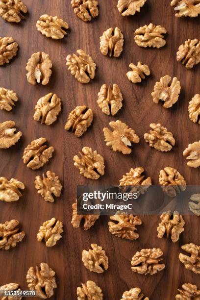 walnut nuts on brown wood - walnut stock pictures, royalty-free photos & images