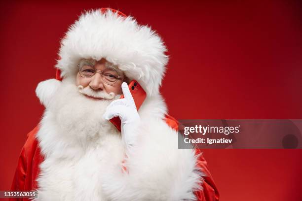 smiling santa is on cell-phone - santa hat and beard stock pictures, royalty-free photos & images