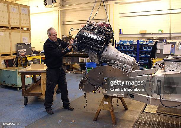 An employee manouvers a Bayerische Motoren Werke AG engine into the chassis of a Morgan Motor Company Ltd. Aero SuperSports automobile at the...