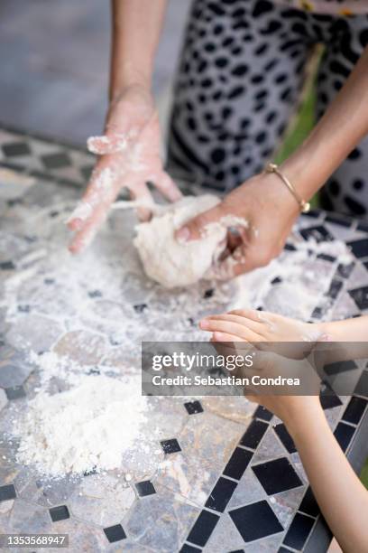 mother and daughter preparing pizza together outside. - italien familie stock-fotos und bilder