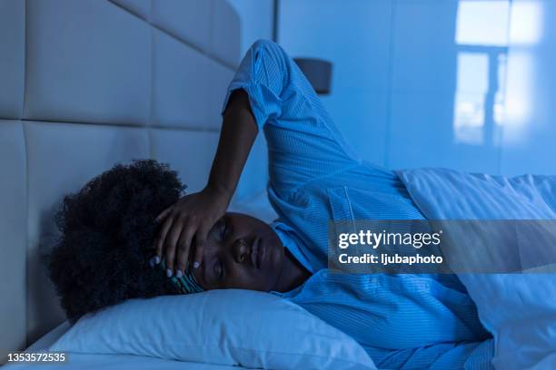 sad woman suffering  while layin in bed at night - negative emotion stockfoto's en -beelden