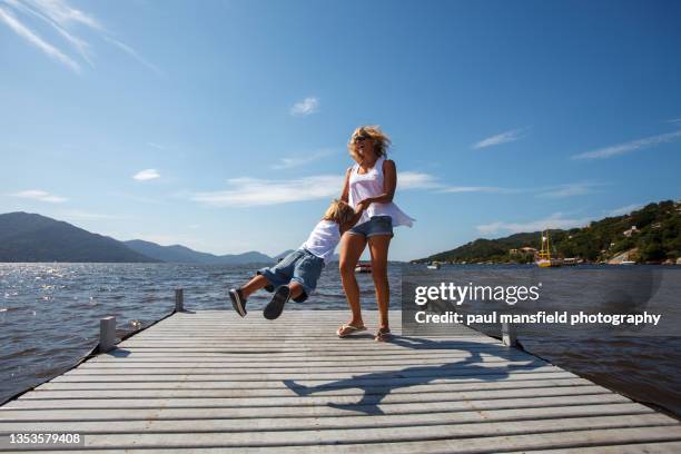 mother and son playing on jetty - florianopolis foto e immagini stock