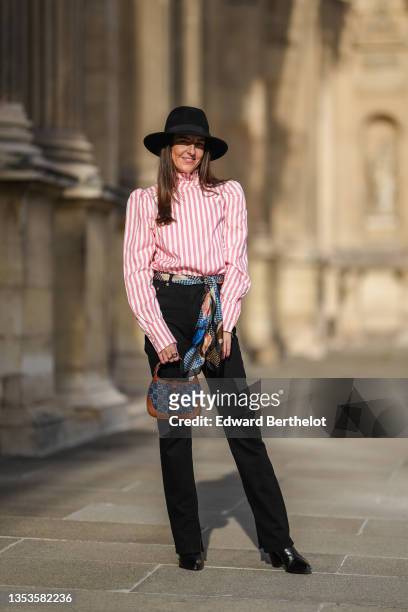 Alba Garavito Torre wears a black felt wool hat, a pale red coral and white striped turtleneck / puffy sleeves blouse / shirt from Nina Blanc, a...