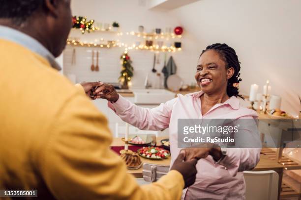 african american senior couple dancing and having fun for christmas eve - senior man dancing on table stock pictures, royalty-free photos & images