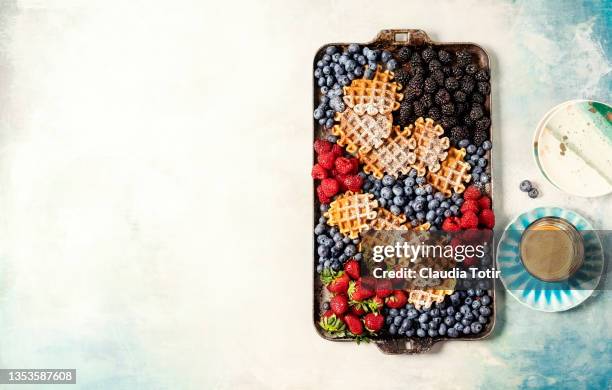 brunch board with waffles and berries on blue background - brambleberry stock pictures, royalty-free photos & images