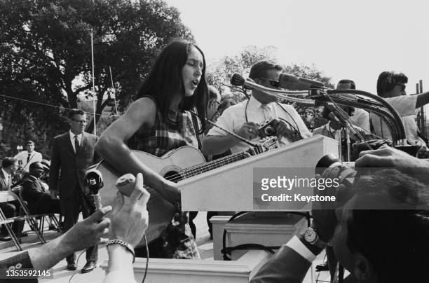 American folk singer and musician Joan Baez performs onstage for the crowd gathered during the March on Washington for Jobs and Freedom, Washington...