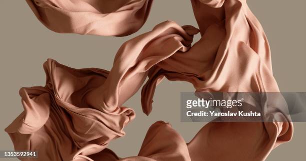 cotton fabrick flowing by wind on beige background stock photo - moda foto e immagini stock