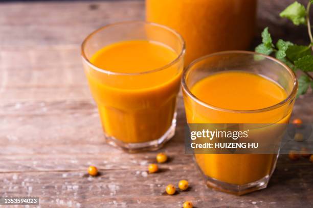 delicious sea buckthorn juice and fresh berries on table - buckthorn stock pictures, royalty-free photos & images