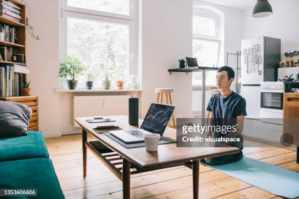 asian man doing yoga at home - speech recognition stockfoto's en -beelden