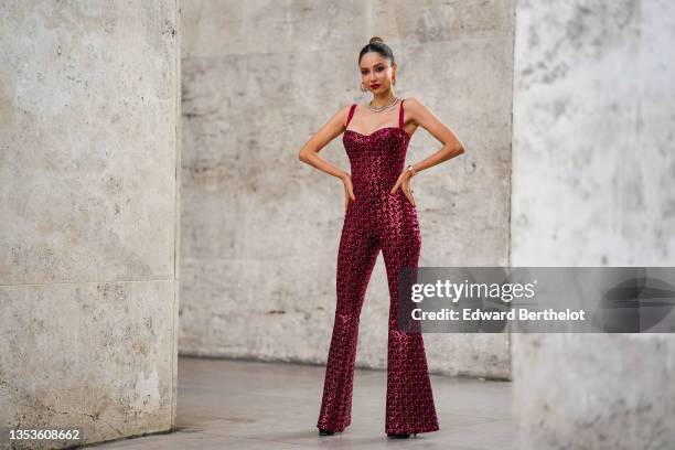 Patricia Gloria Contreras wears gold earrings from Louis Vuitton, a gold chain necklace, a silver and rhinestones necklace, a burgundy velvet with...