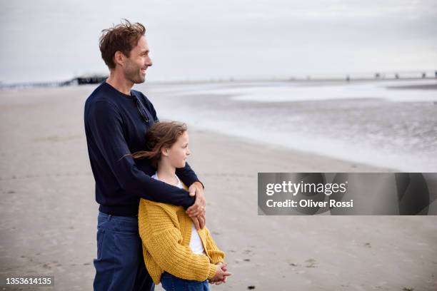 father and daughter on the beach looking at distance - distant family stock pictures, royalty-free photos & images
