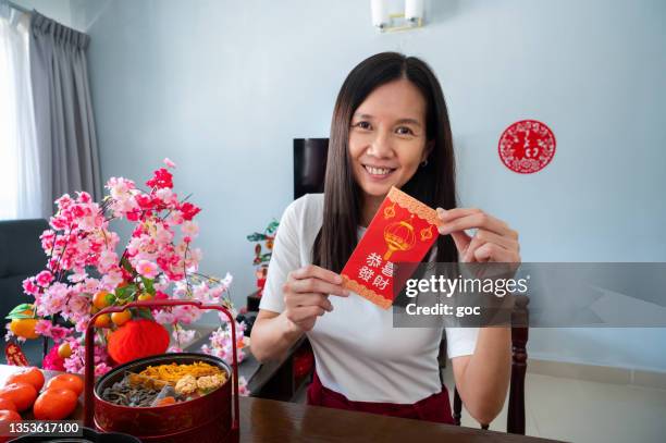 schöne asiatische frau mit rotem umschlag oder ang pow und blickt in die kamera - chinese new year red envelope stock-fotos und bilder