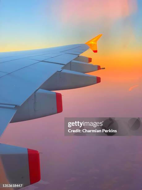 aeroplane wing in flight at sunset with pink sky and reflected golden light in 2021 between london, uk and johannesburg, south africa - business appearance stock pictures, royalty-free photos & images