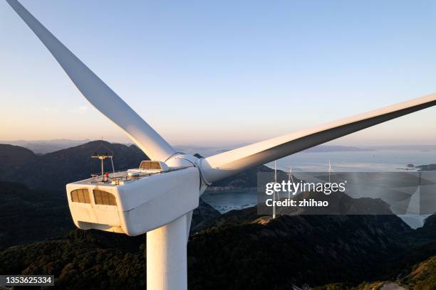 close-up of a wind turbine on the top of a mountain by the sea - mill stock-fotos und bilder