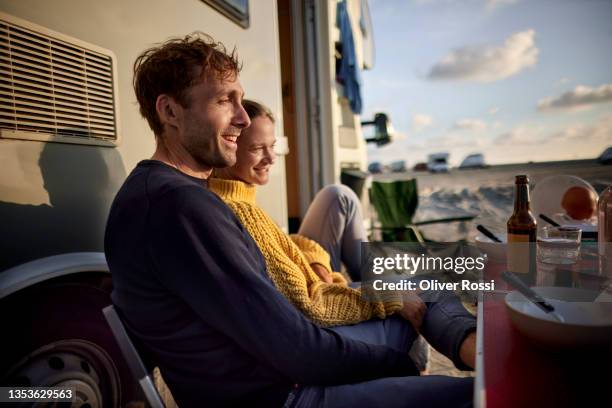 couple relaxing at camper van at sunset - rv beach foto e immagini stock