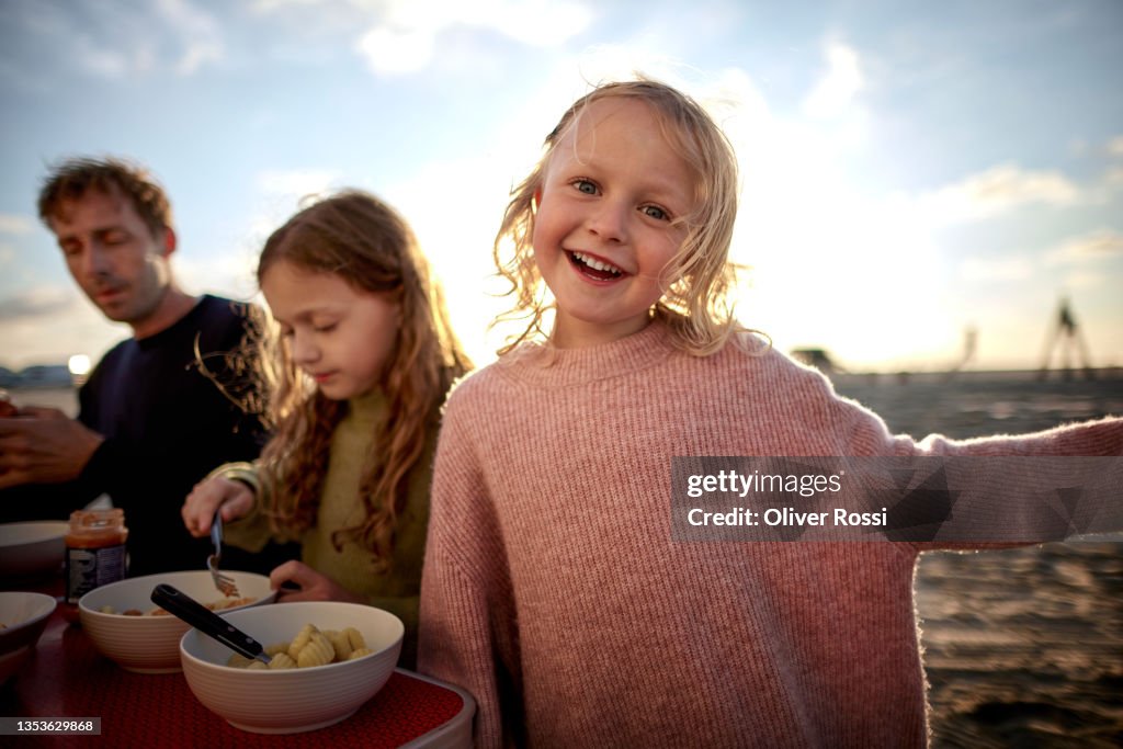 Portrait of happy girl with family at camping table