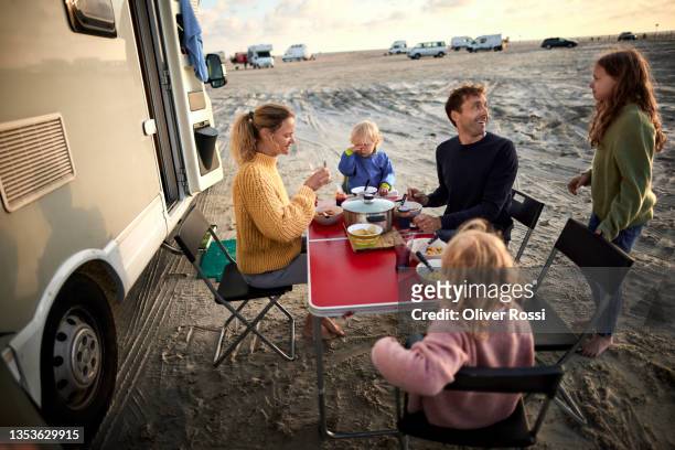 family having dinner at table at camper van - camping chair stock pictures, royalty-free photos & images