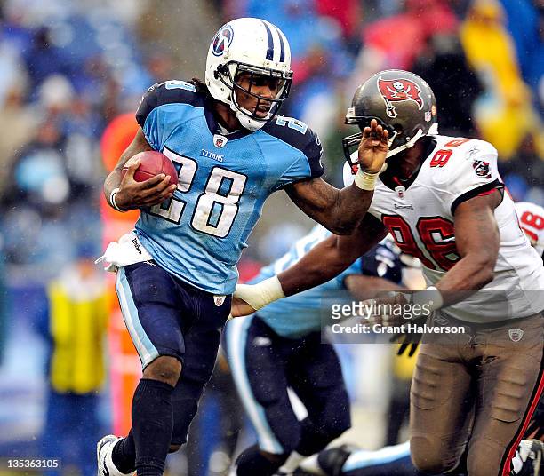 Tim Crowder of the Tampa Bay Buccaneers tackles Chris Johnson of the Tennessee Titans during play at LP Field on November 27, 2011 in Nashville,...
