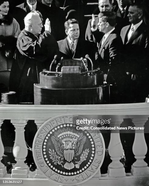 Chief Justice Earl Warren swears in John F Kennedy as the 35th President of the United States on the US Capitol's East Front, Washington DC, January...