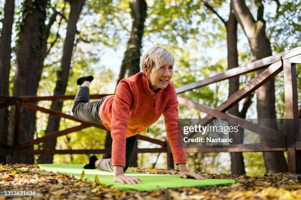 senior woman practicing yoga in park - tai chi shadow stock pictures, royalty-free photos & images