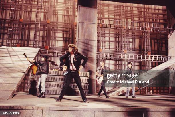 The Rolling Stones performing on the set of the music video for 'One Hit ', England, May 1986. Left to right: Ronnie Wood, Mick Jagger, Keith...
