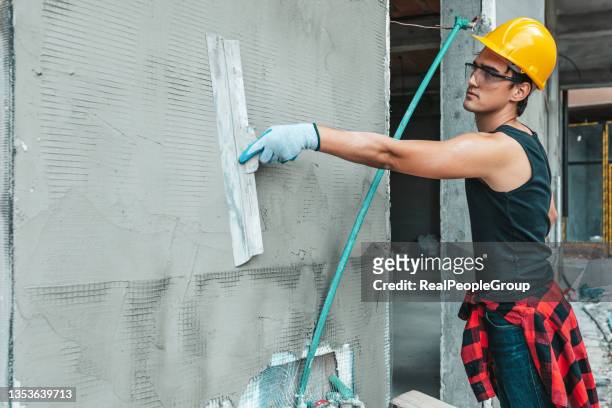 renovation at home. construction worker putting decorative plaster on house exterior - waterproofing stock pictures, royalty-free photos & images