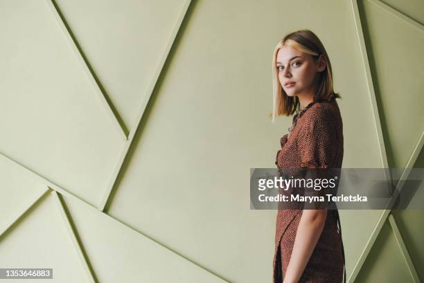 beautiful blonde girl on a light green background. - vestito marrone foto e immagini stock