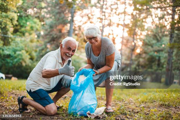 happy seniors cleaning the park - environmental cleanup stock pictures, royalty-free photos & images