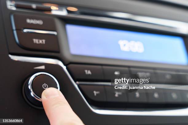 driver pressing a button to turn on the music or radio in the car. - autoradio stock-fotos und bilder