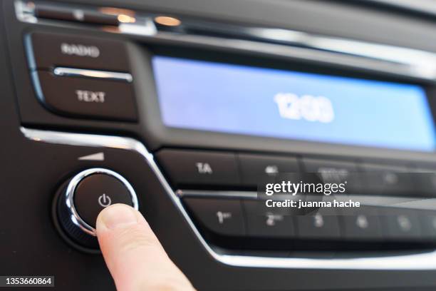 driver pressing a button to turn on the music or radio in the car. - radio foto e immagini stock