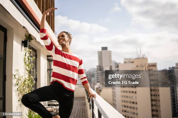 männlicher balletttänzer beim üben auf dem balkon der wohnung - balletttänzer männlich stock-fotos und bilder