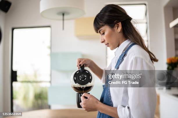 jovem que está servindo café em casa - coffee maker - fotografias e filmes do acervo